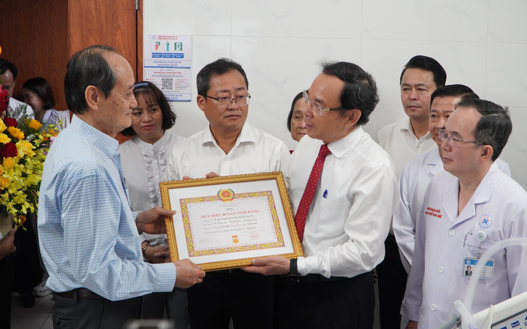 B&iacute; thư Th&agrave;nh ủy Nguyễn Văn N&ecirc;n trao huy hiệu Đảng cho đảng vi&ecirc;n 100 tuổi