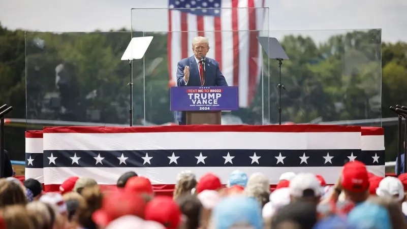&Ocirc;ng Trump ph&aacute;t biểu sau lớp k&iacute;nh chống đạn trong cuộc vận động tranh cử ở TP Asheboro, bang North Carolina, ng&agrave;y 21-8 - Ảnh: Reuters