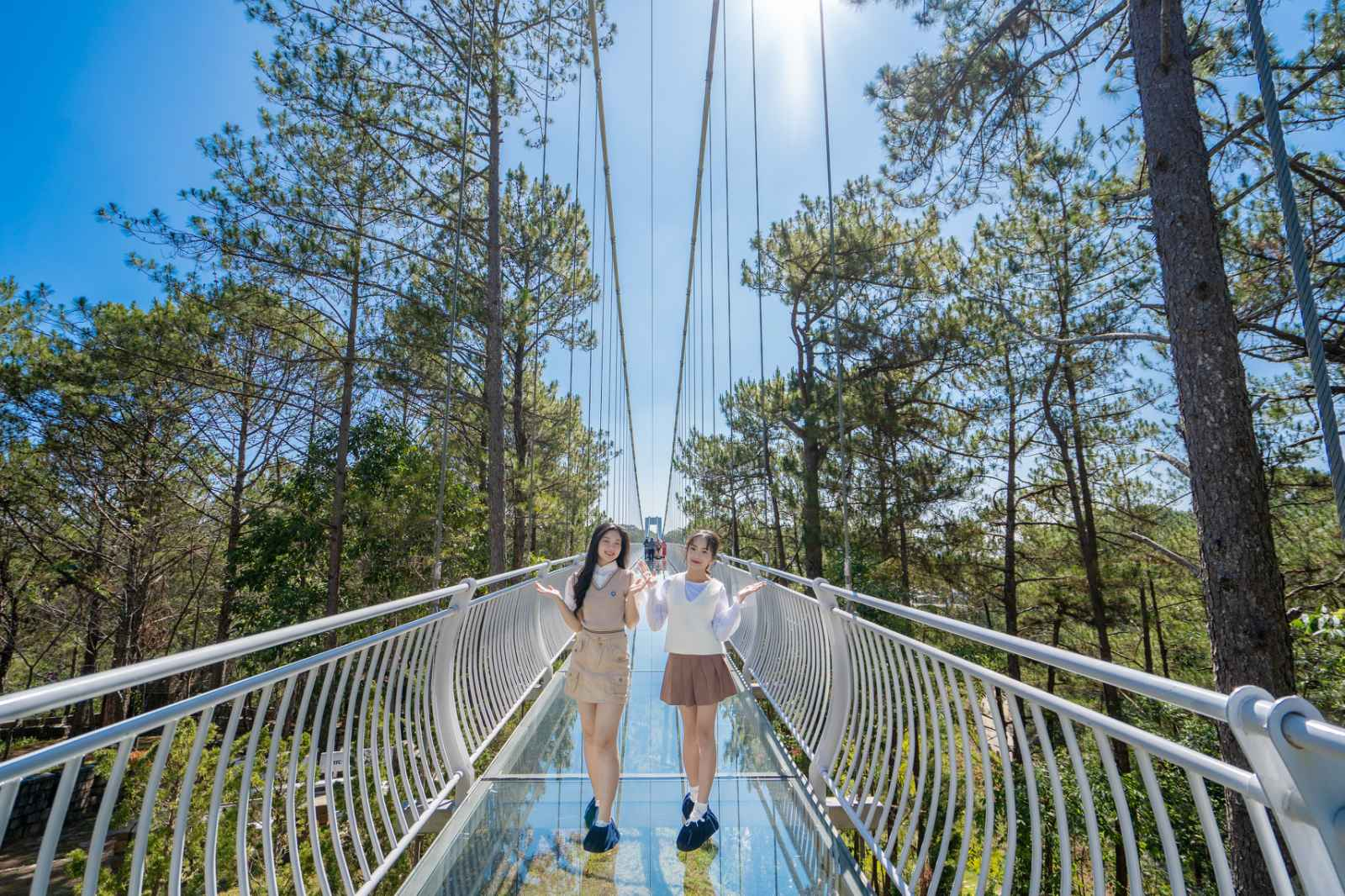 Two women standing on a bridge Description automatically generated