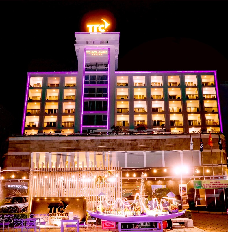A building with lights and a boat in front of it Description automatically generated