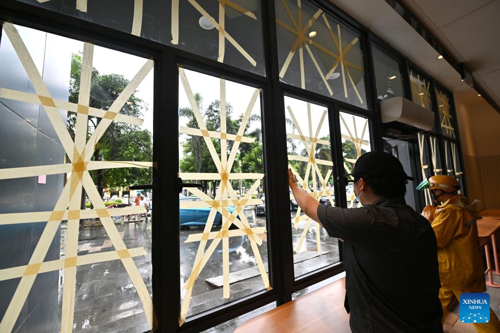 A staff member reinforces a glass window in Haikou, south China's Hainan Province, Sept. 5, 2024. The State Flood Control and Drought Relief Headquarters raised its emergency response for flood and typhoon prevention from level III to level II in Guangdong and Hainan provinces at 3 p.m. Thursday, as typhoon Yagi approaches. Yagi is expected to make landfall on Friday afternoon or evening somewhere between the city of Qionghai in Hainan and Maoming City in Guangdong. (Xinhua/Guo Cheng)