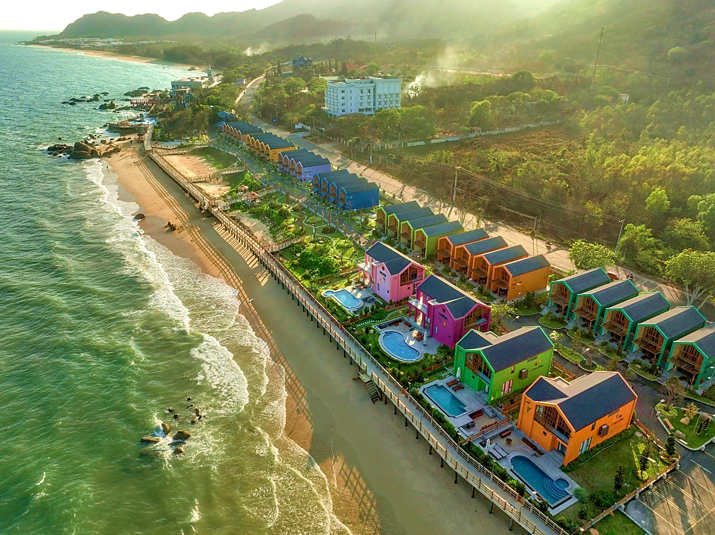 A beach with houses and a body of water Description automatically generated