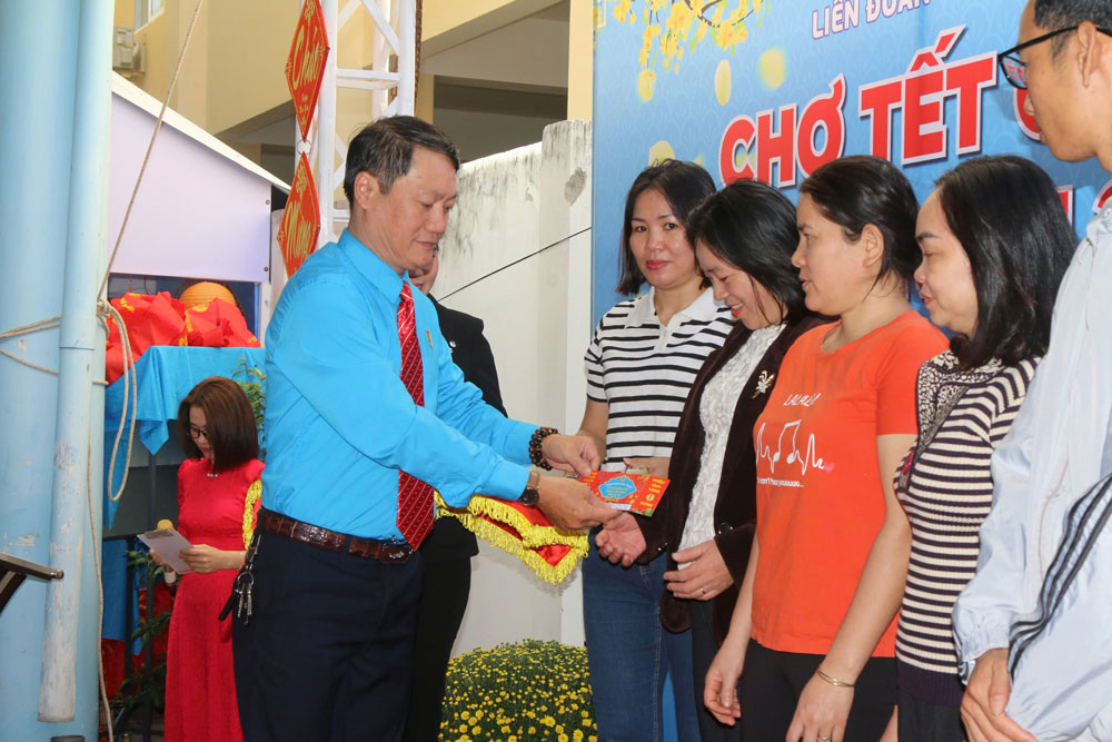 Ông Ngô Anh Duyệt, Chủ tịch LĐLĐ Nha Trang, tặng phiếu mua hàng cho người lao động khó khăn. Ảnh: THÁI TĨNH