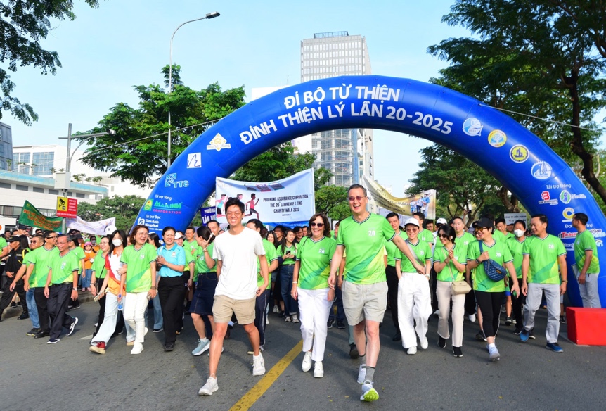 A group of people walking under a blue arch Description automatically generated