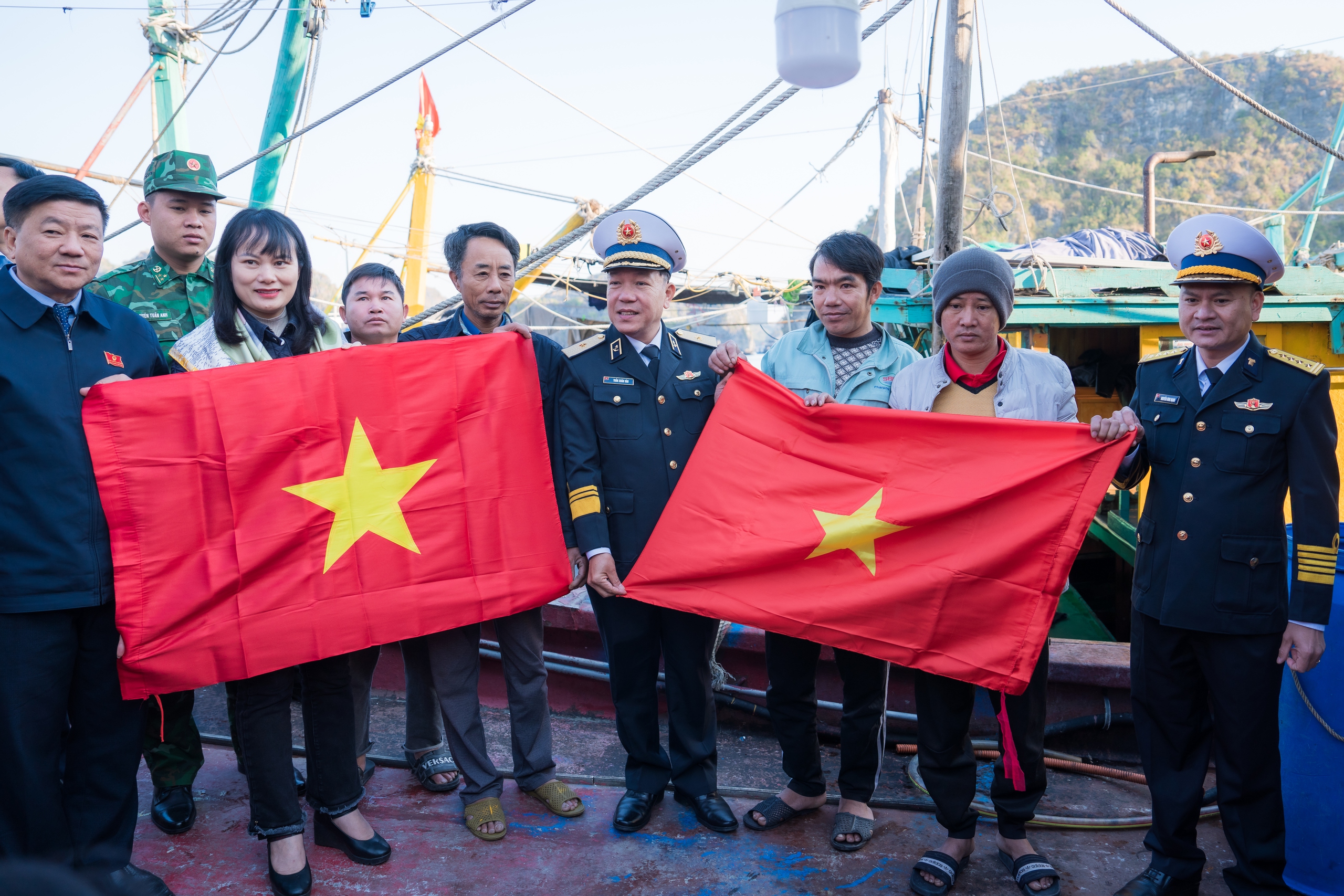 Chuẩn Đ&ocirc; đốc Trần Xu&acirc;n Văn, B&iacute; thư Đảng ủy, Ch&iacute;nh ủy V&ugrave;ng 1 Hải qu&acirc;n trao cờ cho ngư d&acirc;n tại C&aacute;t B&agrave; (Hải Ph&ograve;ng). Ảnh: Vũ Minh Hiển