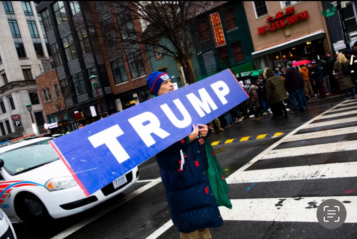 Một người đ&agrave;n &ocirc;ng cầm tấm bảng ghi chữ Trump ở Washington h&ocirc;m 19-1. Ảnh: NBC News