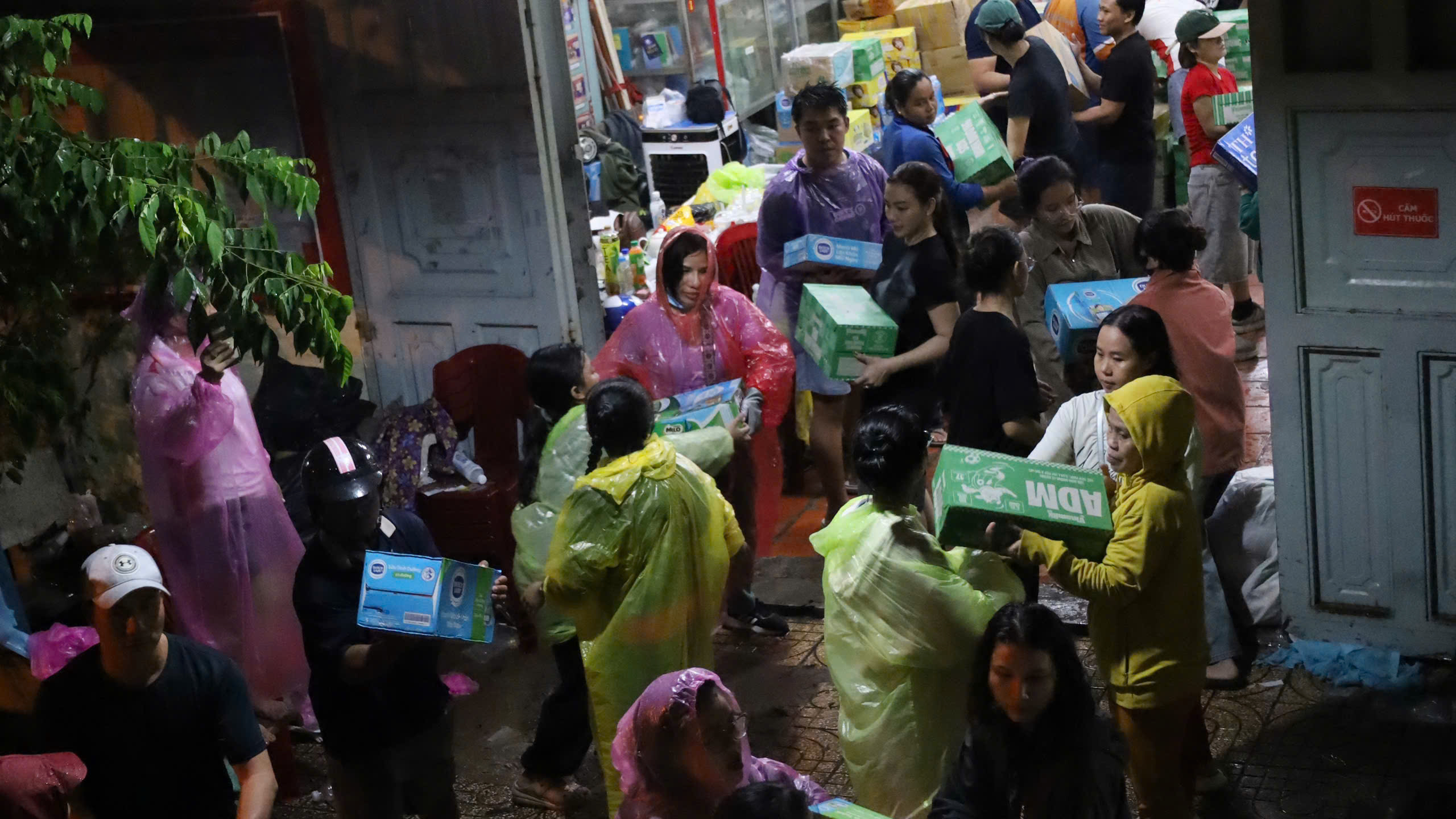Người dân đội mưa, cùng nhau chuyển hàng cứu trợ kịp chuyến xe từ TP HCM ra miền Trung - Ảnh 1.