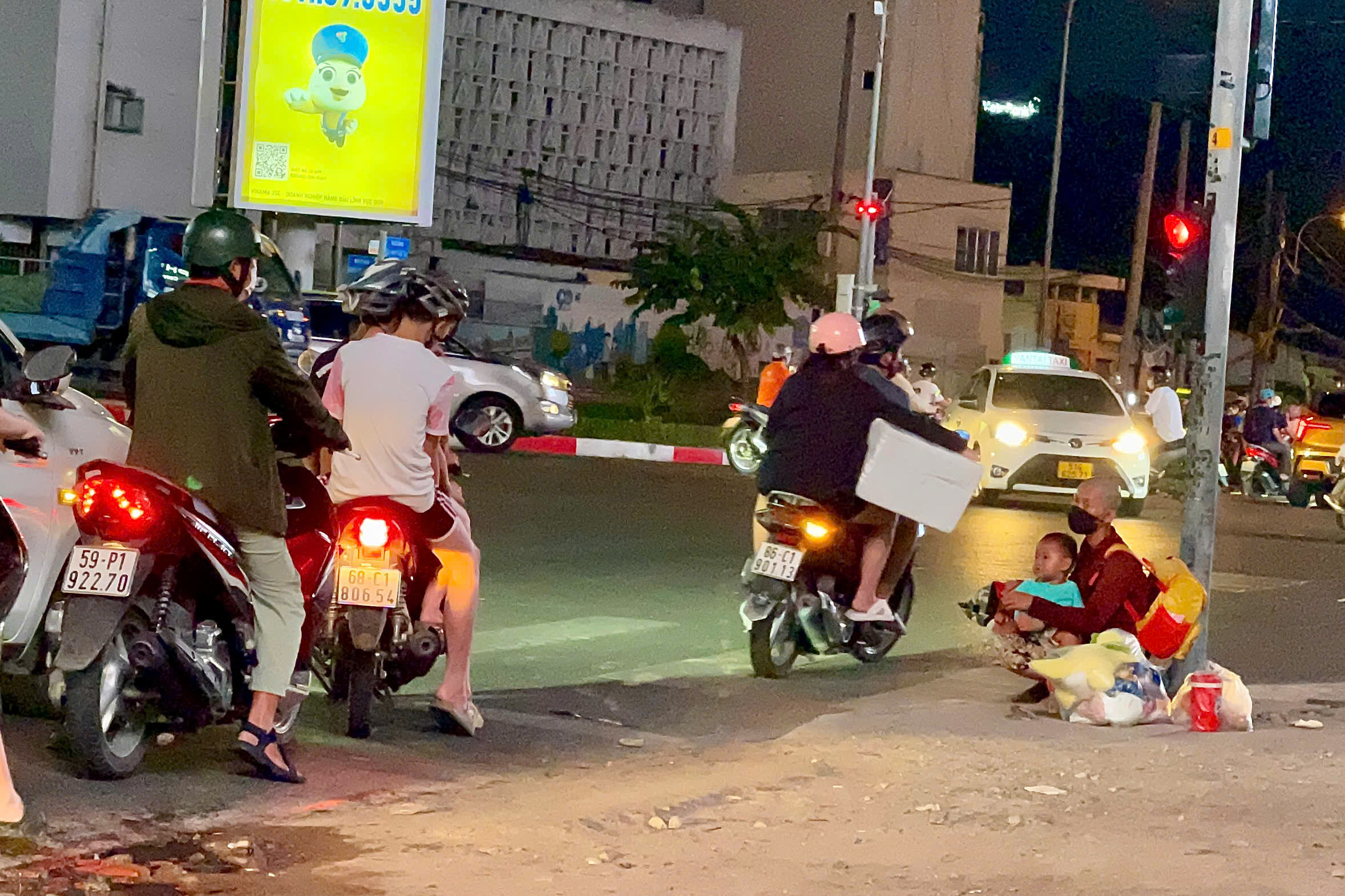 Người phụ nữ bế theo đứa trẻ xin tiền ở ngã tư đường Cách mạng Tháng Tám - Nguyễn Thị Minh Khai (giao quận 1 và quận 3)