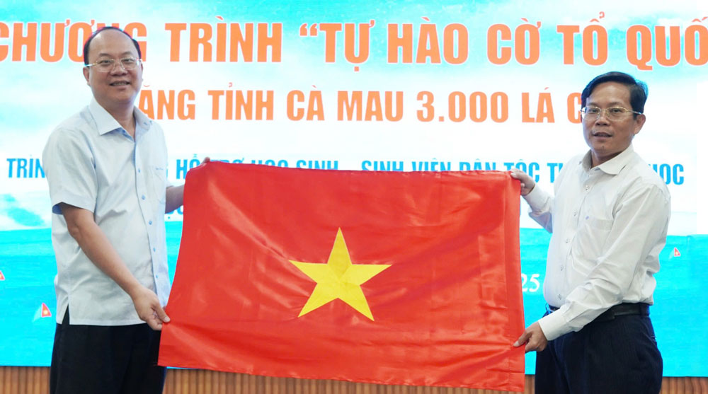 Tổng Biên tập Báo Người Lao Động Tô Đình Tuân (phải) tặng lá cờ Tổ quốc từ chương trình “Tự hào cờ Tổ quốc” cho Bí thư Tỉnh ủy Cà Mau Nguyễn Hồ Hải