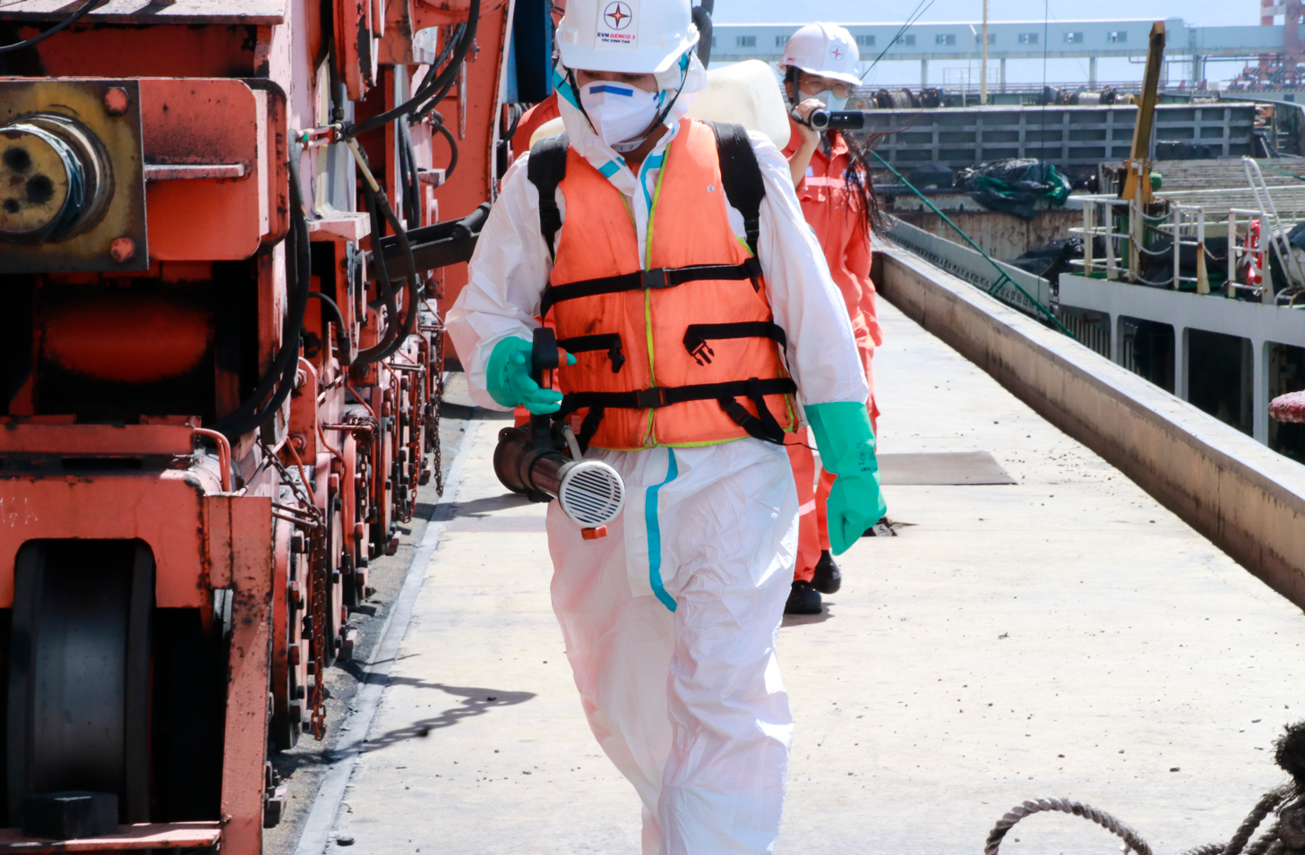 A person in a white protective suit and helmet walking on a dock AI-generated content may be incorrect.