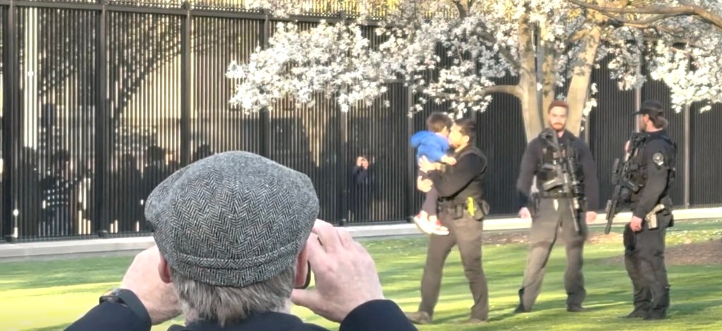 A Secret Service agent holding a child who slipped through the White House fence