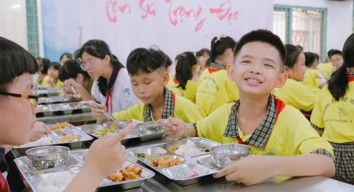 A group of children sitting at a table with food  AI-generated content may be incorrect.