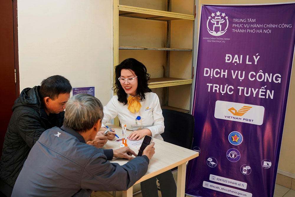 Nhân viên Bưu điện Trung tâm Hoàn Kiếm - số 75 Đinh Tiên Hoàng, TP Hà Nội hướng dẫn người dân thực hiện thủ tục hành chính công. Ảnh: VIETNAM POST