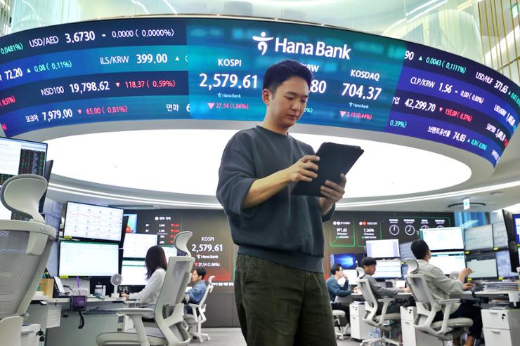 Thông tin chứng khoán, tỉ giá hiển thị tại phòng giao dịch của một ngân hàng ở Hàn Quốc.Ảnh: YONHAP