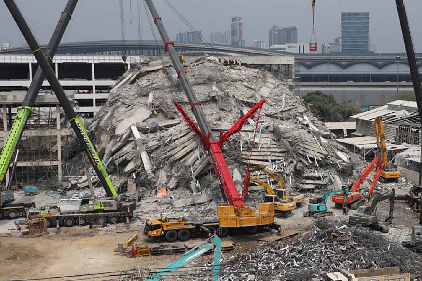 Mountain of debris: Private organisations help out by deploying cranes to clear rubble in the search and rescue effort at a collapsed building site in Chatuchak district of Bangkok on Tuesday. Nutthawat Wichieanbut