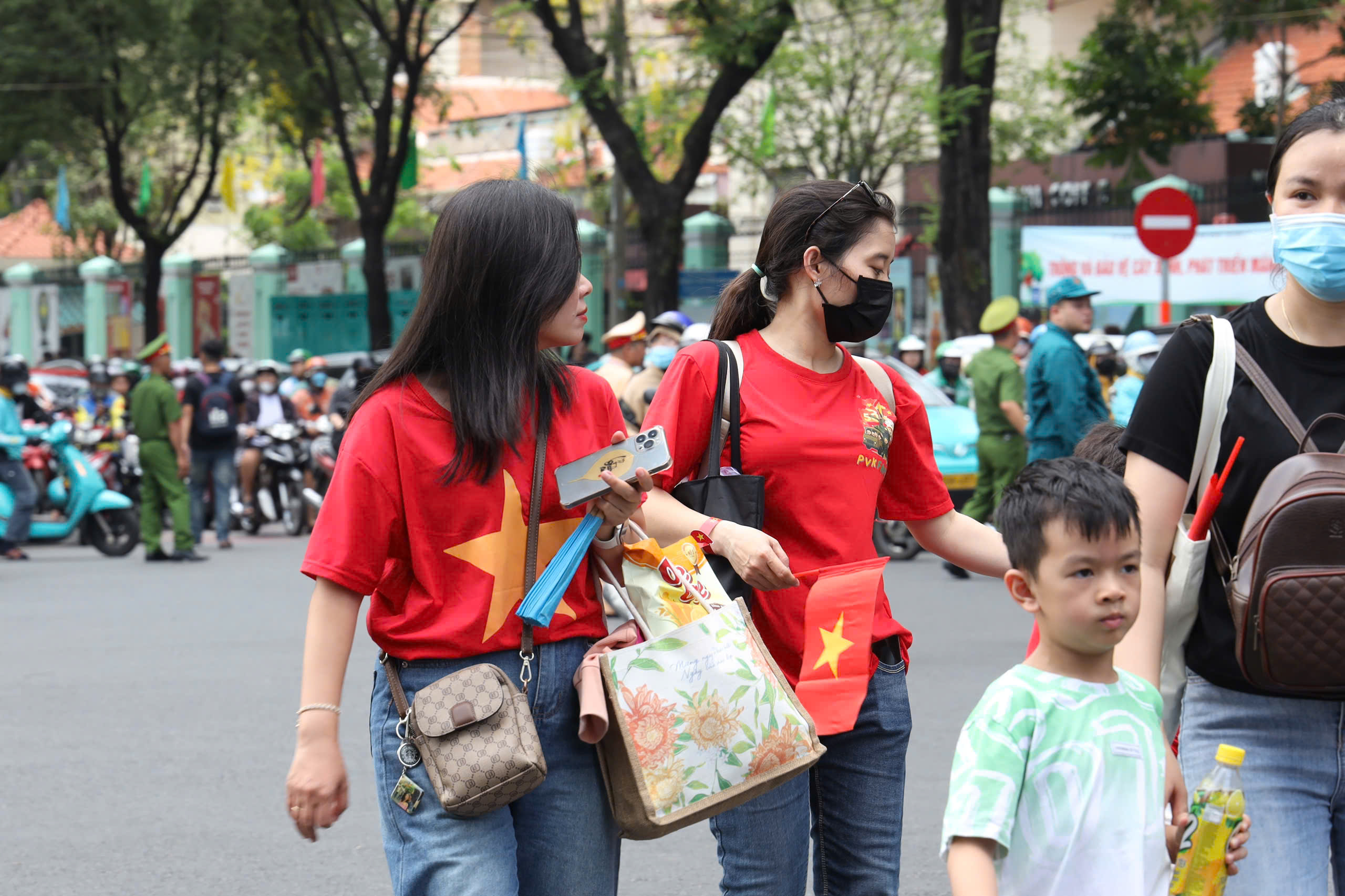 Người d&acirc;n đổ về trung t&acirc;m TP HCM trước giờ sơ duyệt diễu binh, diễu h&agrave;nh tối 25-4- Ảnh 8.