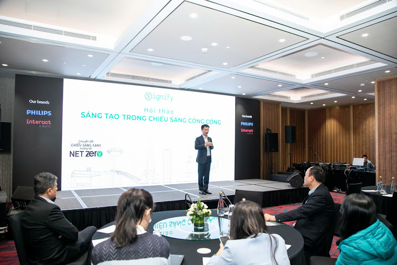 Signify Việt Nam giới thiệu giải pháp chiếu sáng tiên tiến- Ảnh 1. A person standing in front of a large screen Description automatically generated
