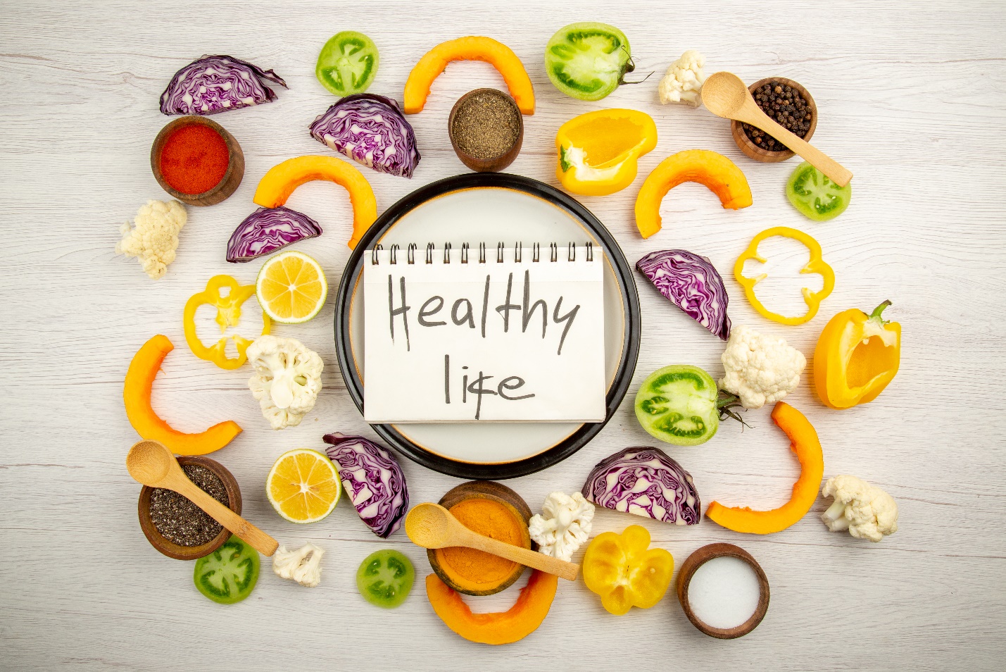 A notebook surrounded by vegetables  Description automatically generated