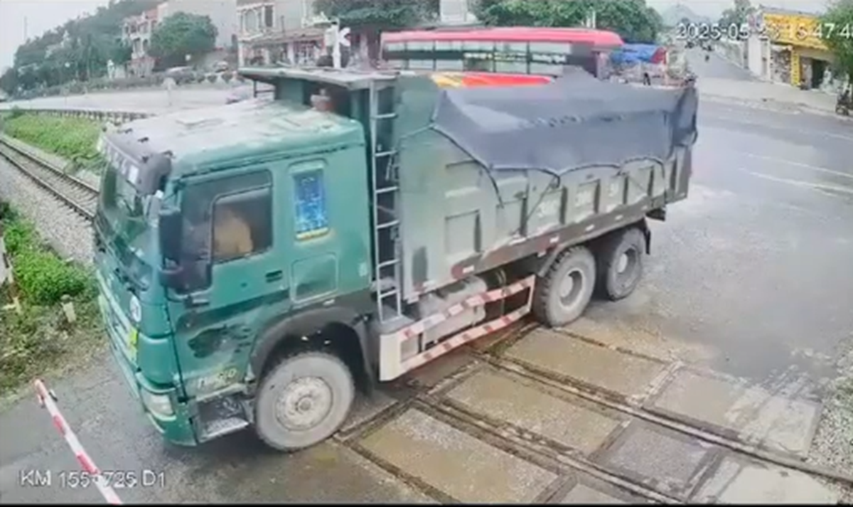 VIDEO: Xe "hổ vồ" tông gãy rào chắn, băng qua đường sắt khi tàu đến gần - Ảnh 1.