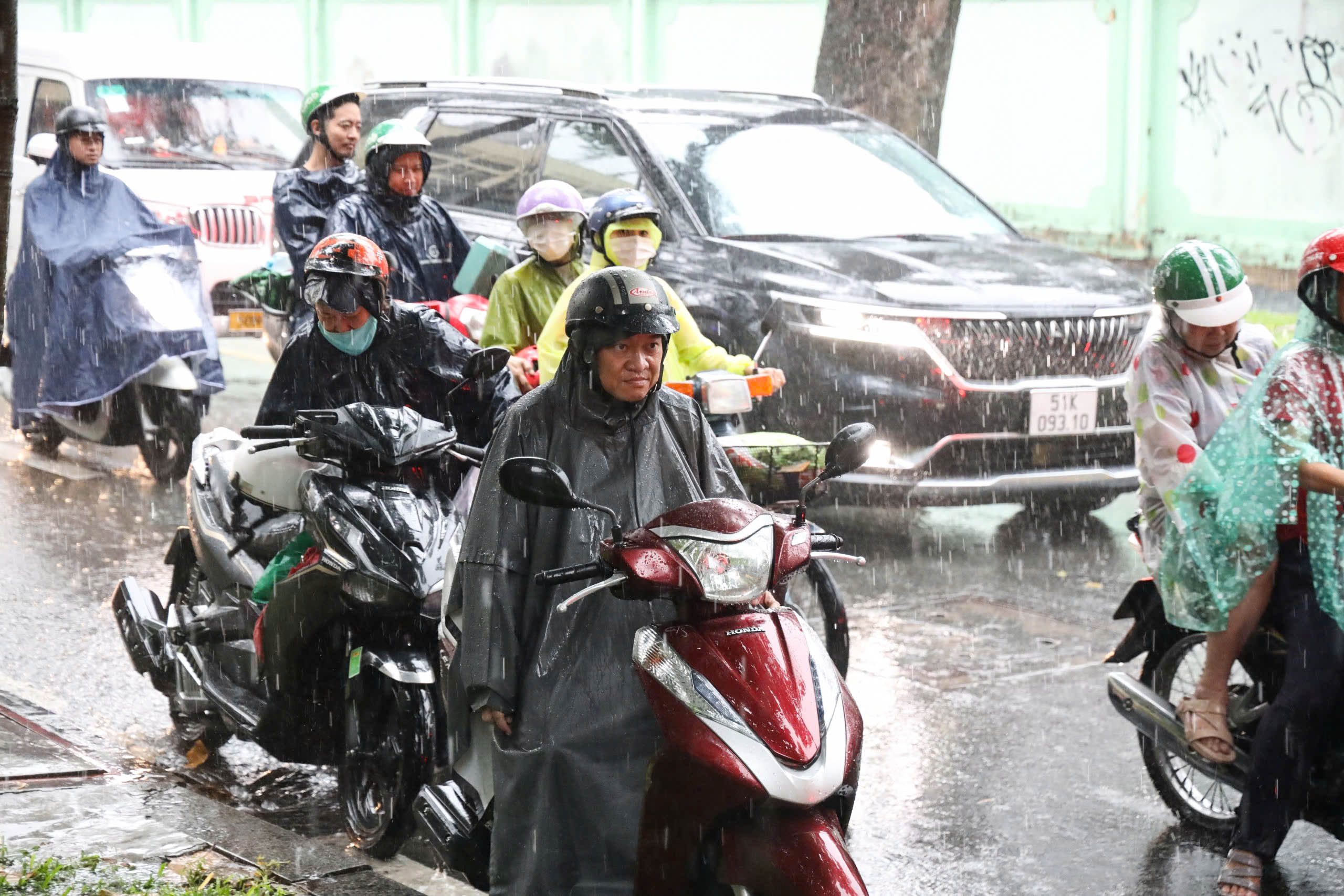 Không ngại mưa to, phụ huynh ở TP HCM vẫn bám trụ trước điểm thi chờ con- Ảnh 1.