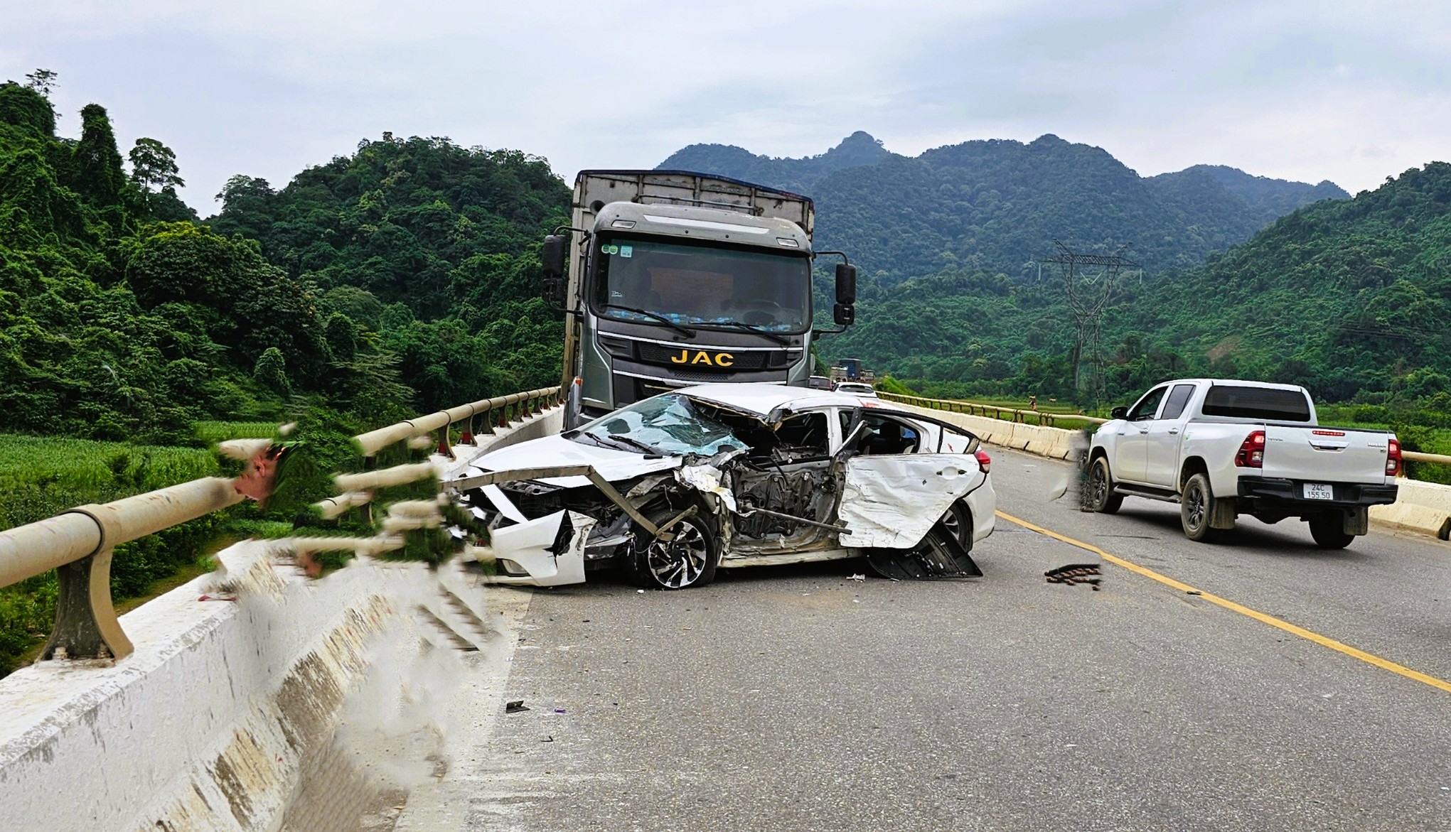 Tông nhau trên cầu, xe tải văng xuống vực, tài xế ô tô con tử vong, 5 người khác bị thương- Ảnh 1.