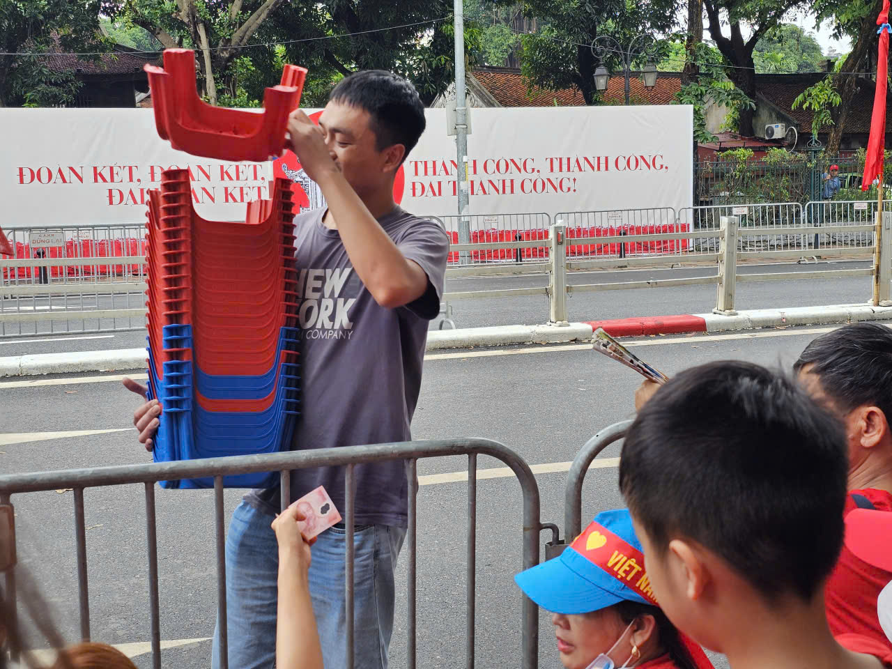 Người d&acirc;n cho&aacute;ng v&aacute;ng với gi&aacute; ghế nhựa v&agrave; chai nước trong diễu binh diễu h&agrave;nh - Ảnh 1.