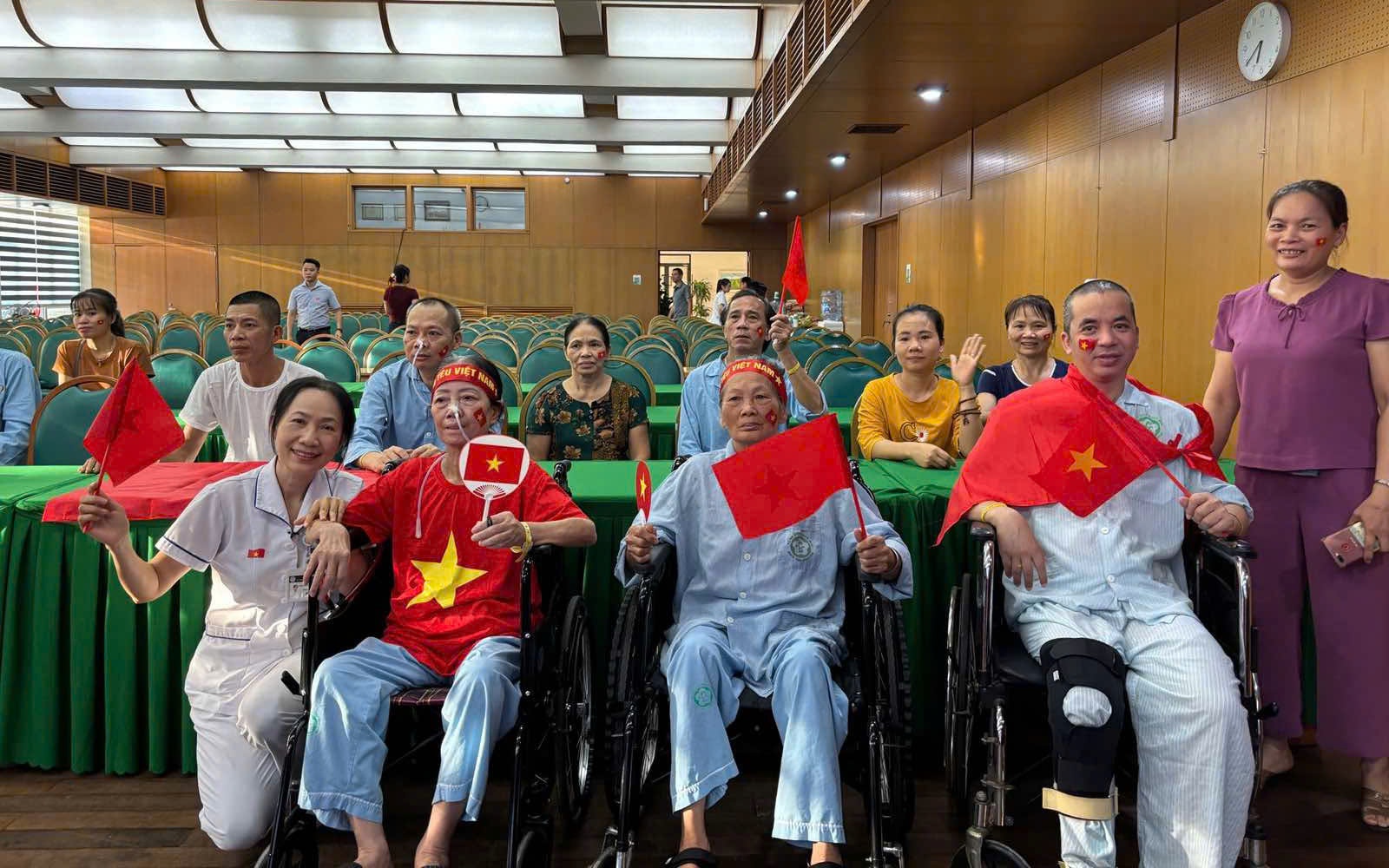 Bệnh nhân ngồi xe lăn, đeo dây truyền háo hức xem trực tiếp lễ diễu binh