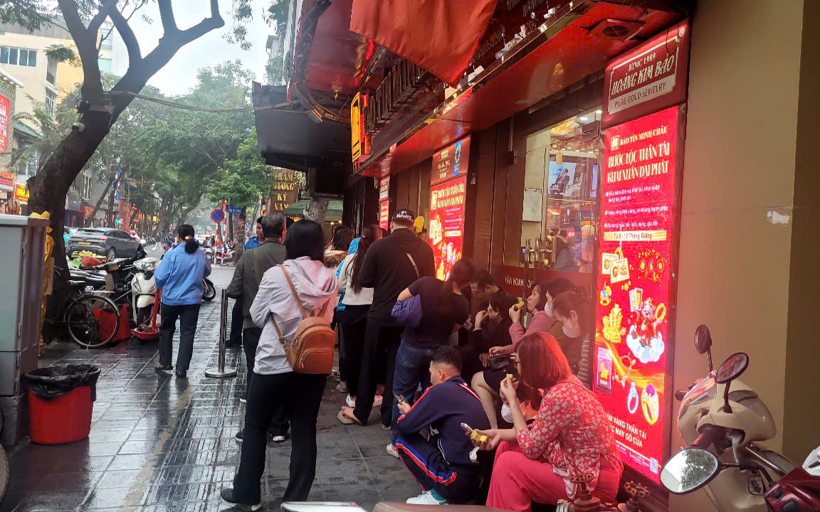 Người dân đội mưa xếp hàng chờ mua vàng trước ngày vía Thần Tài