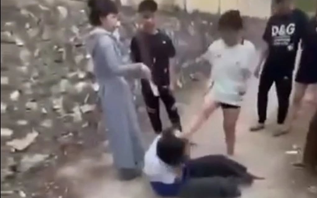 Một thiếu nữ mặc áo học sinh bị đánh hội đồng đến bất tỉnh