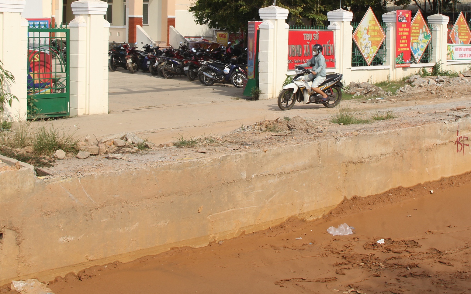 Quốc lộ 14B đào xới dang dở, dân vượt “hào sâu” mới vào được cổng ủy ban