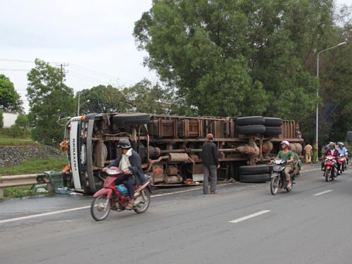 Tông xe khách, xe tải lật nhào giữa đường