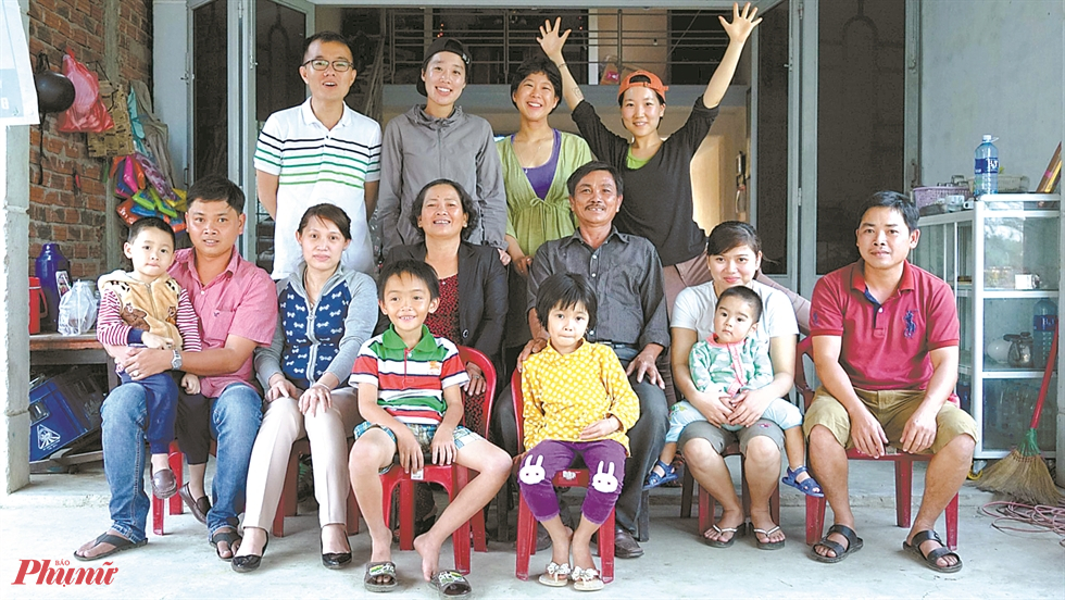 Đạo diễn Lee-Kil, thứ hai từ tr&aacute;i sang h&agrave;ng thứ ba, chụp ảnh với Nguyễn Thị Th&agrave;nh, thứ tư từ h&agrave;ng thứ hai b&ecirc;n tr&aacute;i, đo&agrave;n quay phim v&agrave; gia đ&igrave;nh của Nguyễn trước nh&agrave; Nguyễn ở l&agrave;ng Phong Nhi, Việt Nam, v&agrave;o ng&agrave;y 4 th&aacute;ng 3 năm 2016