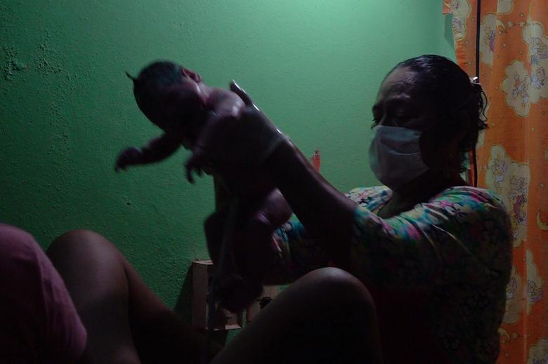 Nữ hộ sinh Juanita Zarate Solorza gi&uacute;p Mariana, 29 tuổi, sinh đứa con thứ ba tại một ph&ograve;ng kh&aacute;m địa phương thay v&igrave; một bệnh viện gần đ&oacute; ở Union Hidalgo, Mexico h&ocirc;m 19/4. 