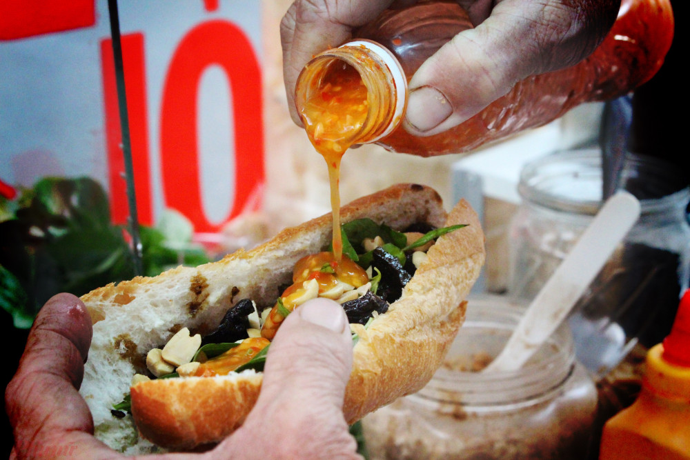 B&aacute;nh m&igrave; kh&ocirc; b&ograve; c&oacute; c&aacute;ch phối vị kh&aacute; đơn giản. Xẻ dọc ổ b&aacute;nh m&igrave;, cho kh&ocirc; b&ograve; (thịt, l&aacute;ch, gan b&ograve;), rau răm, c&aacute;c loại rưới l&ecirc;n một loại nước d&ugrave;ng v&agrave; sốt m&agrave;u đen, th&ecirc;m &iacute;t đậu phộng rang v&agrave;ng. Cuối c&ugrave;ng l&agrave; k&eacute;o một đường tương ớt dọc th&acirc;n b&aacute;nh. Khi ăn, ngo&agrave;i hương thơm, vị ngon của kh&ocirc; b&ograve;, l&agrave; hương thơm của rau răm, gi&ograve;n của đậu phộng khiến m&oacute;n ăn c&agrave;ng dậy vị v&agrave; hấp dẫn.  Chia sẻ về c&aacute;c th&agrave;nh phần trong m&oacute;n b&aacute;nh, chồng chị Li&ecirc;n cho hay, từ kh&ocirc; b&ograve;, nước sốt đen c&oacute; m&ugrave;i hoa hồi, tương ớt đều do anh tự đi chợ, chọn nguy&ecirc;n liệu v&agrave; chế biến theo c&ocirc;ng thức ri&ecirc;ng gia đ&igrave;nh anh tự t&igrave;m ra. &ldquo;Hơi mất thời gian v&agrave; chi ph&iacute; cũng cao hơn so mua h&agrave;ng c&oacute; sẵn. B&ugrave; lại, m&oacute;n ăn của m&igrave;nh c&oacute; hương vị ri&ecirc;ng&rdquo;.   Kh&ocirc;ng khẳng định, b&aacute;nh m&igrave; kh&ocirc; b&ograve; của m&igrave;nh hơn hẳn nhiều chỗ kh&aacute;c, song anh n&oacute;i th&ecirc;m ai đ&atilde; từng ăn b&aacute;nh th&igrave; kh&ocirc;ng muốn ăn nơi kh&aacute;c. Ri&ecirc;ng kh&ocirc; b&ograve;, v&agrave;o thời điểm gần Tết, anh phải l&agrave;m gấp ba, gấp bốn lần nhiều Việt kiều đặt h&agrave;ng gửi đi nước ngo&agrave;i.