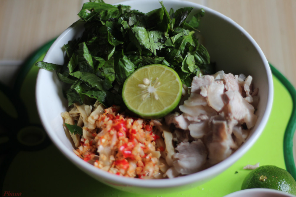 L&acirc;̀n lượt cho măng, rau thơm, thịt ba chỉ, tỏi ớt vào t&ocirc;, tr&ocirc;̣n đ&ecirc;̀u.