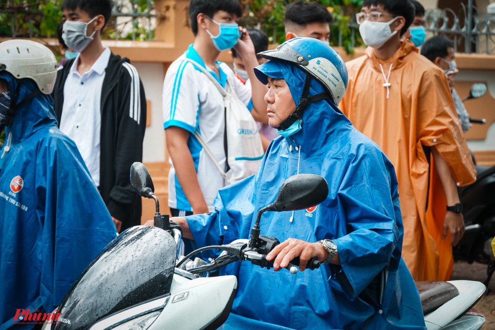 Nhiều phụ huynh đ&atilde; đội mưa hơn 1 giờ đồng hồ chờ con l&agrave;m thủ tục dự thi
