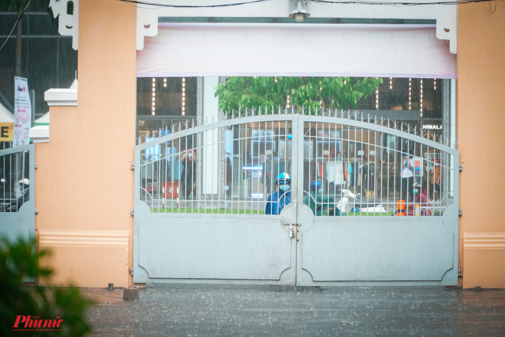 D&ugrave; mưa rất lớn, nhưng vẫn c&oacute; nhiều phụ huynh đứng chờ con ngo&agrave;i cổng trường