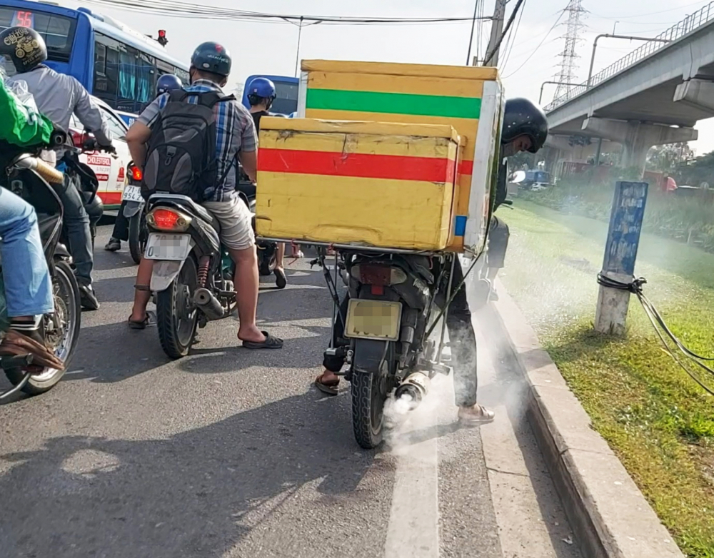 Một chiếc xe m&aacute;y cũ chở h&agrave;ng cồng kềnh, xả kh&oacute;i m&ugrave; mịt chạy từ hướng TP.Thủ Đức về trung t&acirc;m TP.HCM