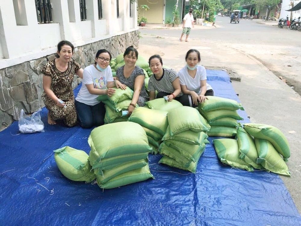 Đại diện chi hội c&ugrave;ng c&aacute;c nh&agrave; hảo t&acirc;m chuẩn bị ph&aacute;t gạo cho người kh&oacute; khăn
