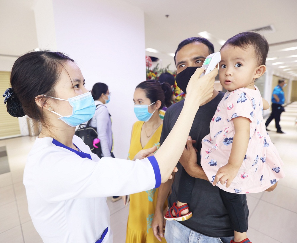 VNVC T&acirc;n Ph&uacute; tiến h&agrave;nh đo nhiệt độ ph&acirc;n luồng ngay tại cửa ra v&agrave;o trung t&acirc;m. Ảnh: VNVC