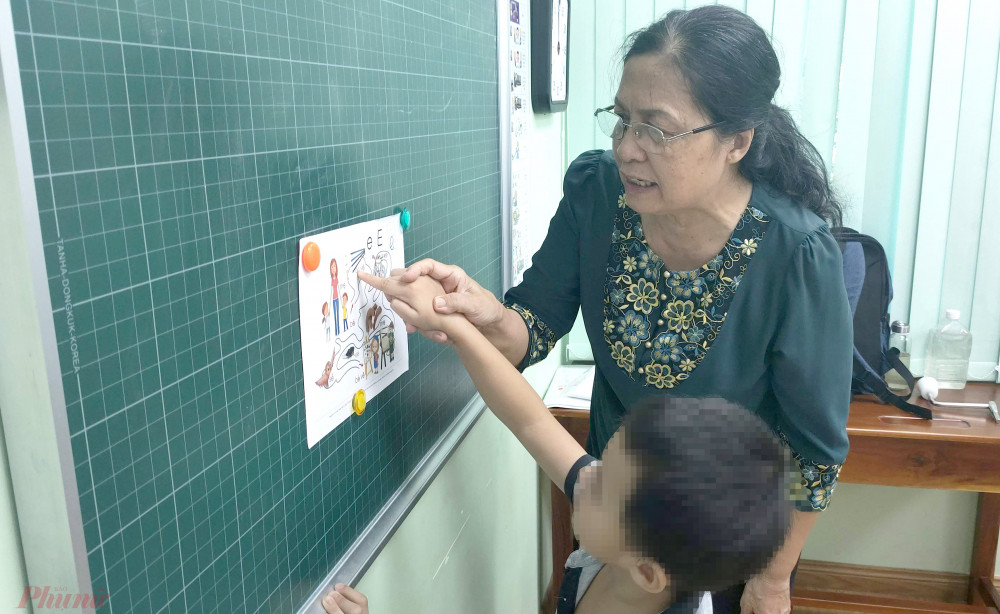 Phó giáo sư Nguyễn Thị Ly Kha đang hướng dẫn bé K.L. học vần qua bài tập tìm đường đi