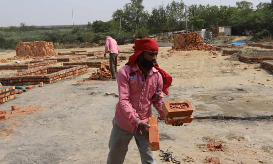 C&ocirc;ng nh&acirc;n gấp r&uacute;t x&acirc;y dựng bệ hỏa t&aacute;ng mới b&ecirc;n ngo&agrave;i một l&ograve; hỏa t&aacute;ng ở New Delhi