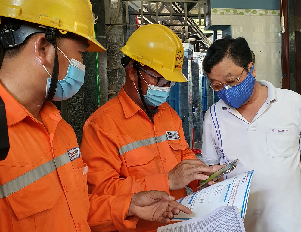Nh&acirc;n vi&ecirc;n C&ocirc;ng ty Điện lực Thủ Đức hướng dẫn người d&acirc;n c&agrave;i App EVNHCMC CSKH. Ảnh: EVNHCMC
