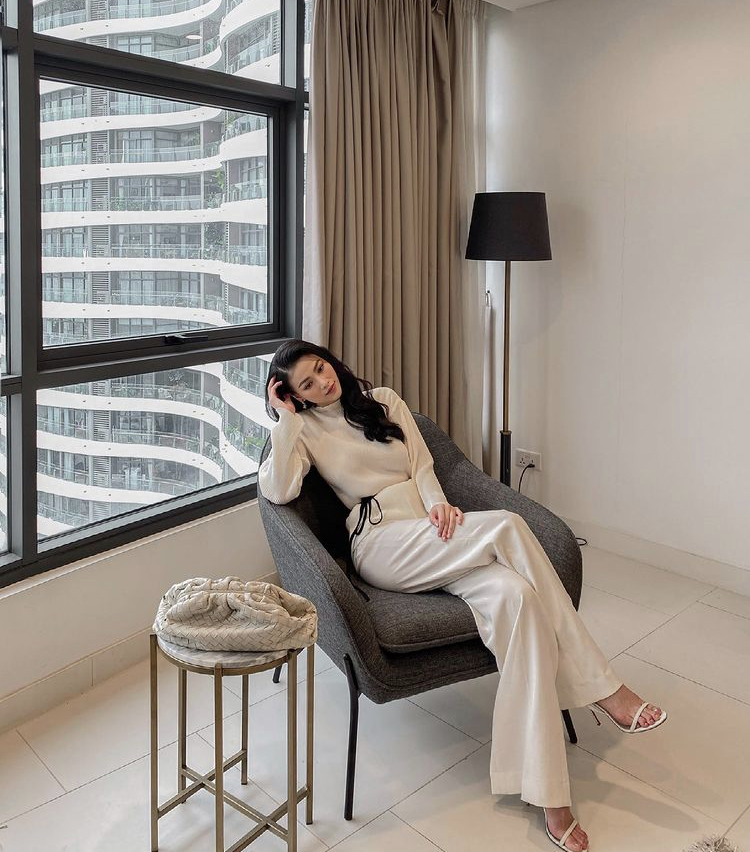 Tại một g&oacute;c kh&aacute;c ở nh&agrave;, n&agrave;ng hậu thay đồ với set quần ống loe kết hợp &aacute;o tay d&agrave;i c&ugrave;ng sắc m&agrave;u trắng kem đơn giản m&agrave; sang chảnh.