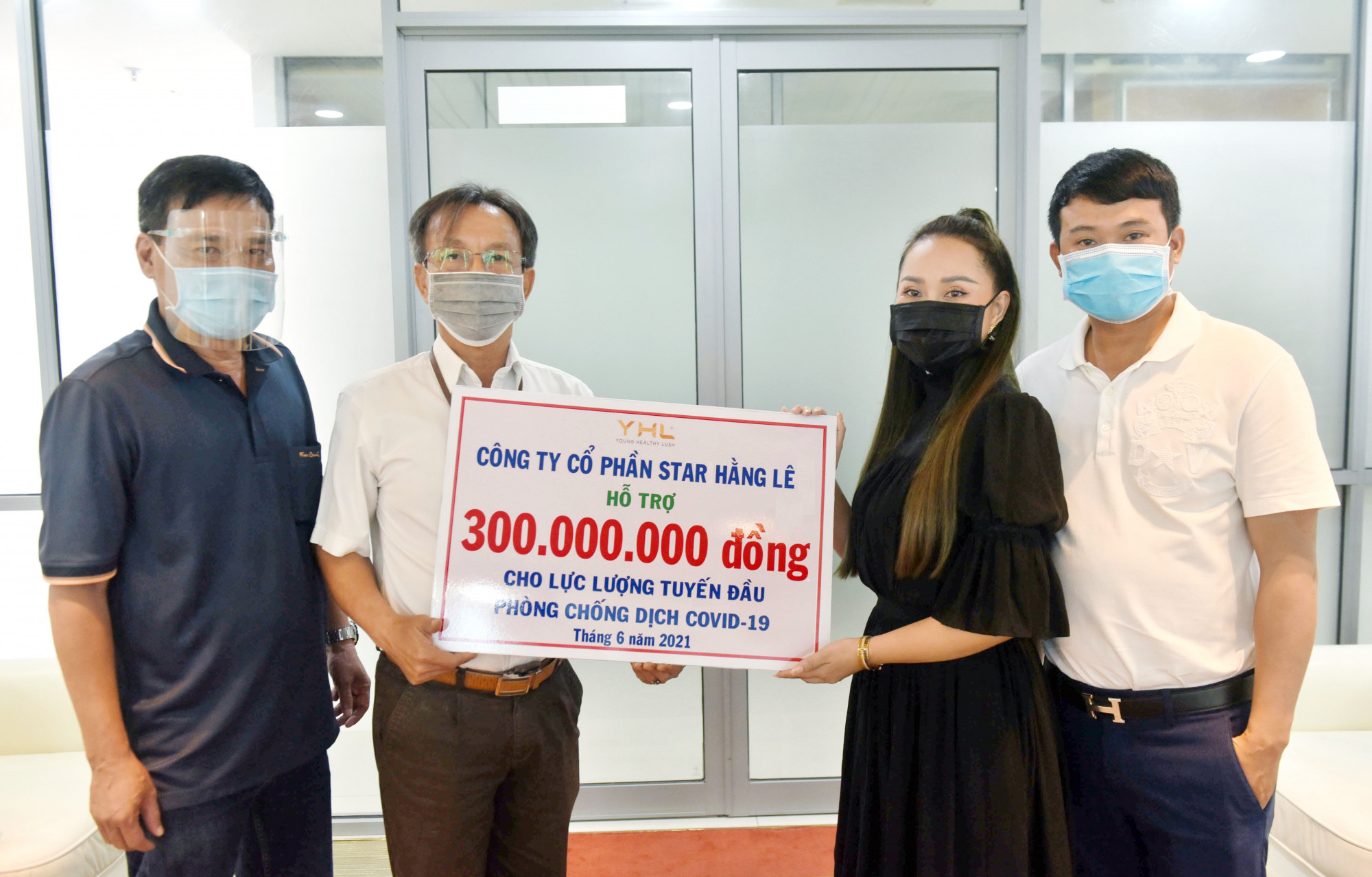 B&agrave; Hằng L&ecirc; (phải) - người s&aacute;ng lập thương hiệu YHL Star Hằng L&ecirc; trao tặng 300 triệu đồng cho lực lượng tuyến đầu chống dịch COVID-19. Ảnh: YHL Star Hằng