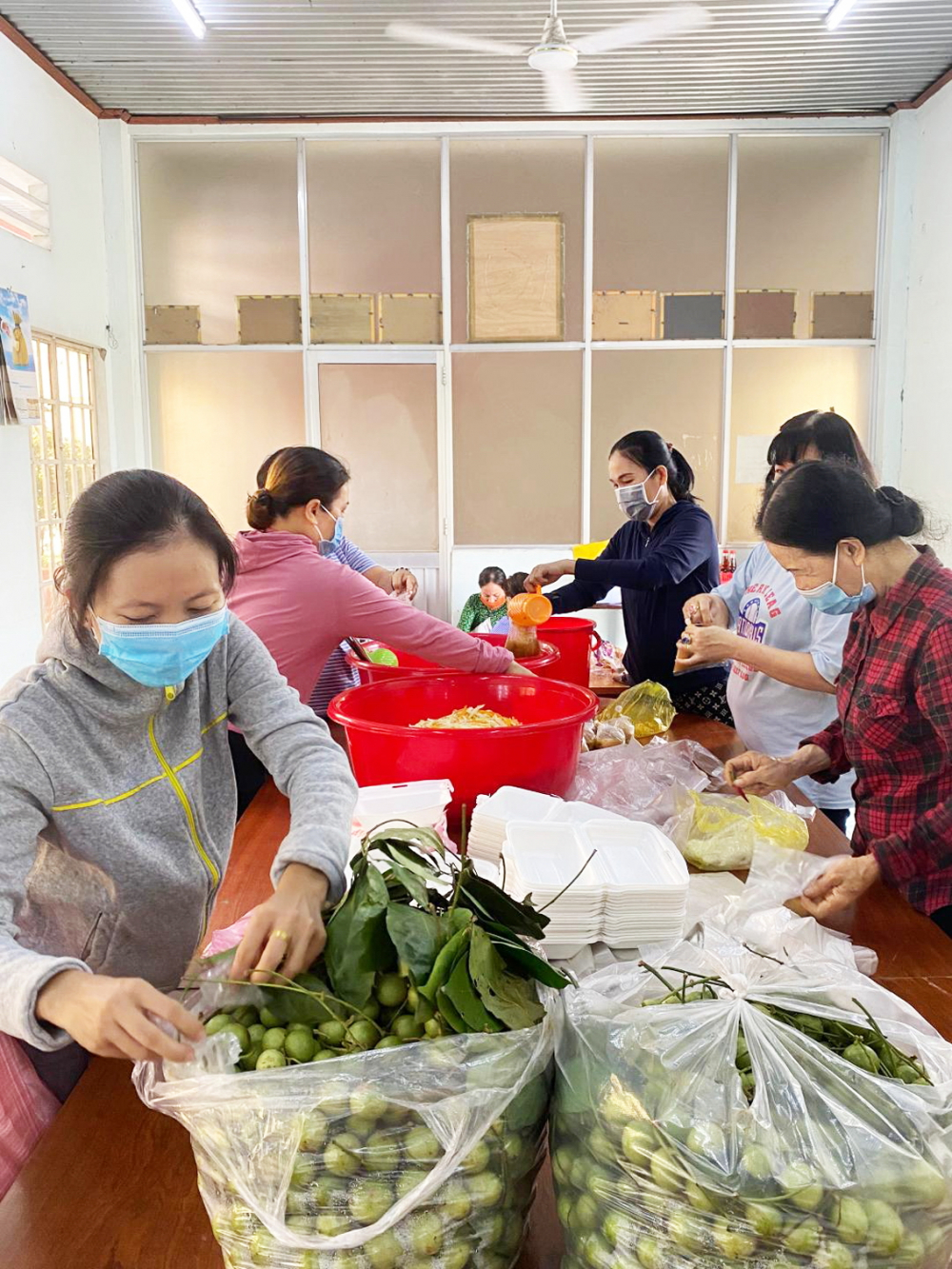 Phụ nữ xã Xuân Thới Sơn nấu cơm và chuẩn bị món tráng miệng chi viện cho khu cách ly