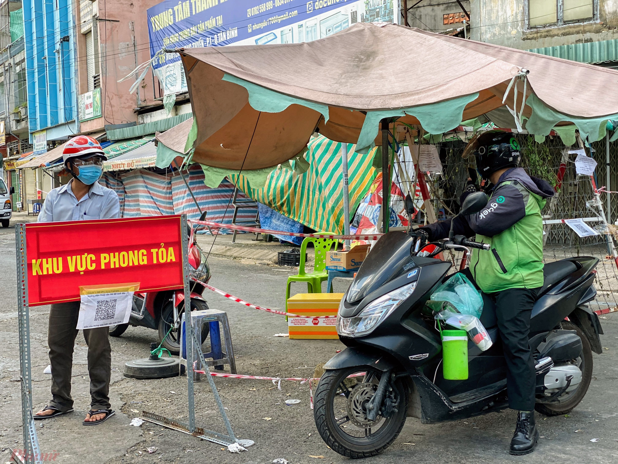 Người  d&acirc;n ở trong khu vực phong toả vẫn được ra v&agrave;o khi  cần  thiếtt, ri&ecirc;ng  nhưng  người  giao  h&agrave;ng, hoặc người  li&ecirc;n hệ sẽ  bị từ chối v&agrave;o khu vực  phong toả cạnh  chợ Phạm Văn Hai.
