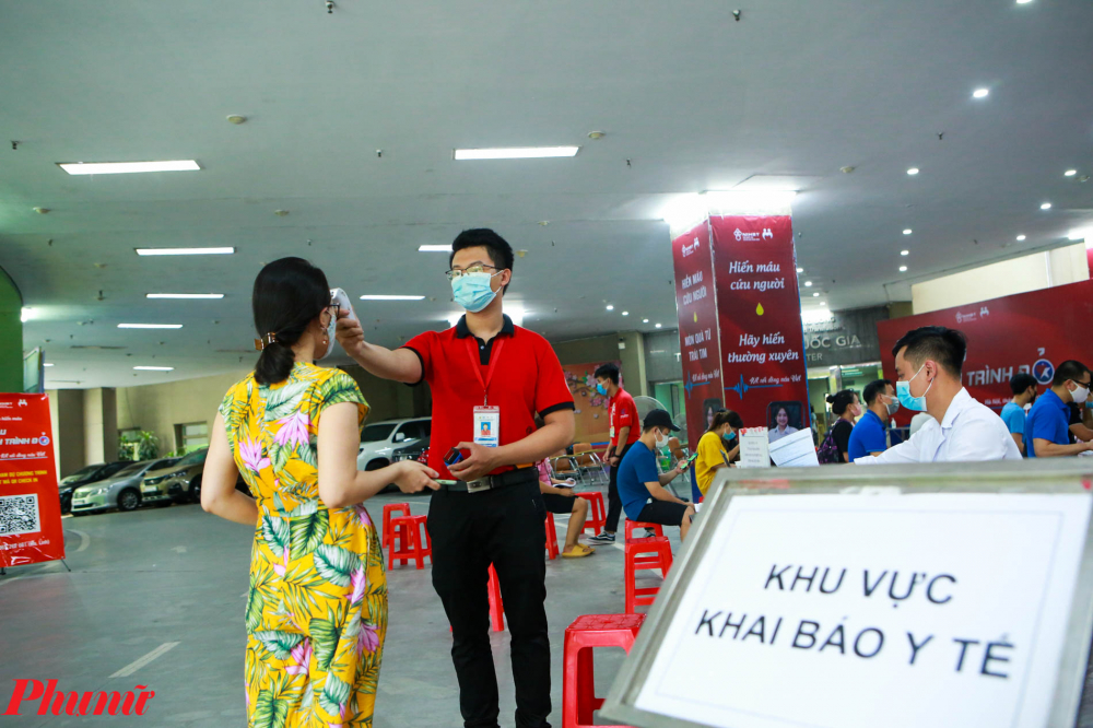 Người d&acirc;n đi hiến m&aacute;u được nh&acirc;n vi&ecirc;n y tế đo th&acirc;n nhiệt từ b&ecirc;n ngo&agrave;i, kiểm tra việc đeo khẩu trang v&agrave; y&ecirc;u cầu s&aacute;t khuẩn, khai b&aacute;o y tế.