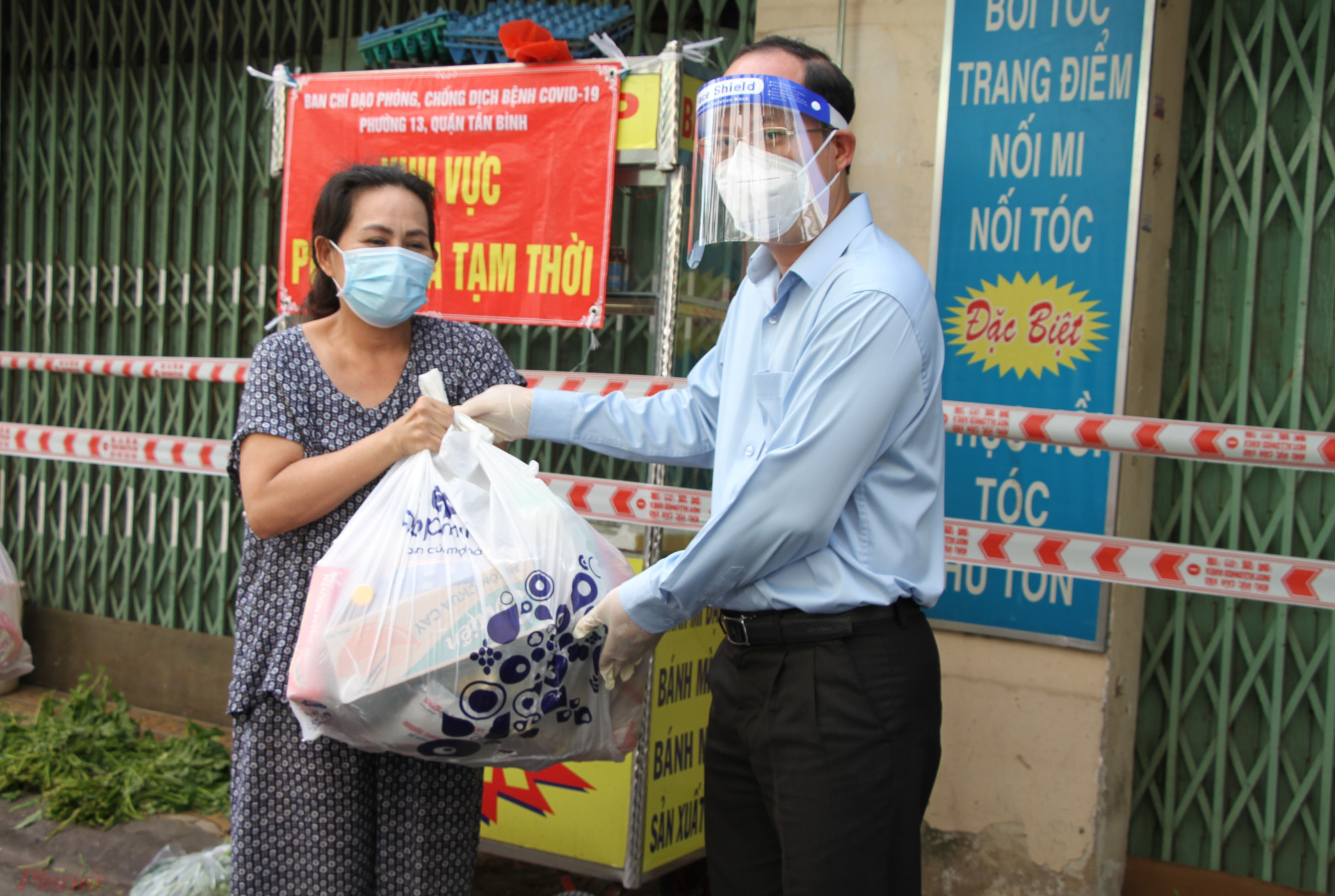Ph&oacute; b&iacute; thư Th&agrave;nh ủy TPHCM Nguyễn Hồ Hải trao qu&agrave; động vi&ecirc;n lực lượng trực chốt, v&agrave; người d&acirc;n c&oacute; ho&agrave;n cảnh kh&oacute; khăn b&ecirc;n trong khu phong tỏa hẻm 56, đường Văn Chung, phường 13, quận T&acirc;n B&igrave;nh