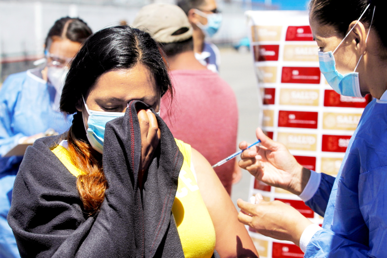 Một phụ nữ sống trong trại di cư El Chaparral gần bi&ecirc;n giới Mỹ ở Tijuana, Mexico được ti&ecirc;m liều vắc-xin Pfizer đầu ti&ecirc;n - ẢNH: REUTERS